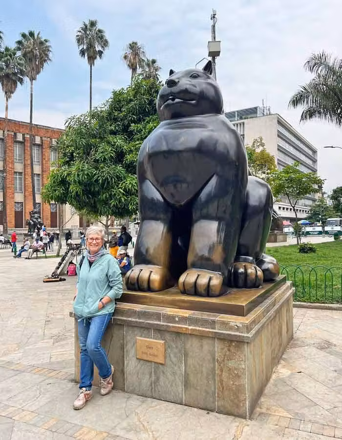 Sania en el centro de Medellín frente a una escultura de un gato