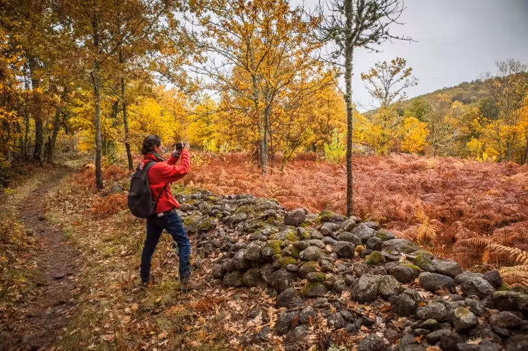 mujer haciendo una foto en otoño en el valle de Ambroz