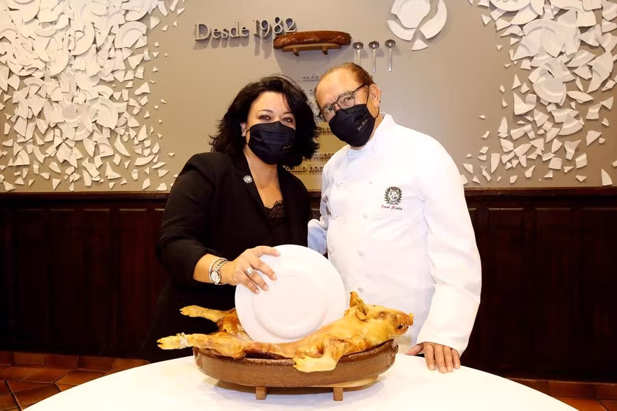 José María y su hija Rocío en el ritual de partir el cochinillo.