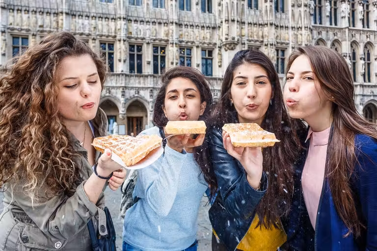 tres jóvenes se toman un gofre en bruselas