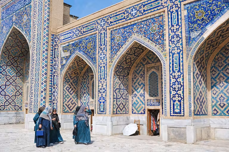 Mujeres paseando por el interior de la madrasa de Tilya Kori, en la plaza de Registán. © Susana García