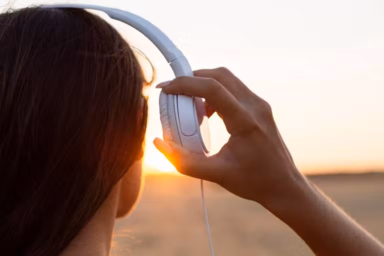 mujer escuchando música al atardecer