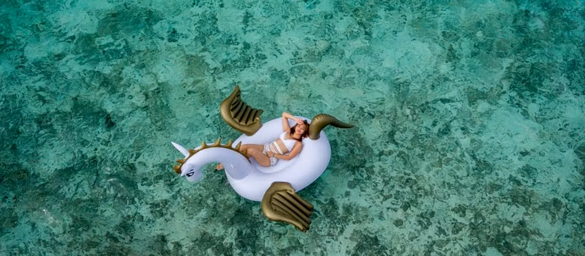 Mujer flotando en el mar en Maldivas