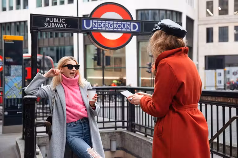 dos chicas con el móvil en el metro de Londres