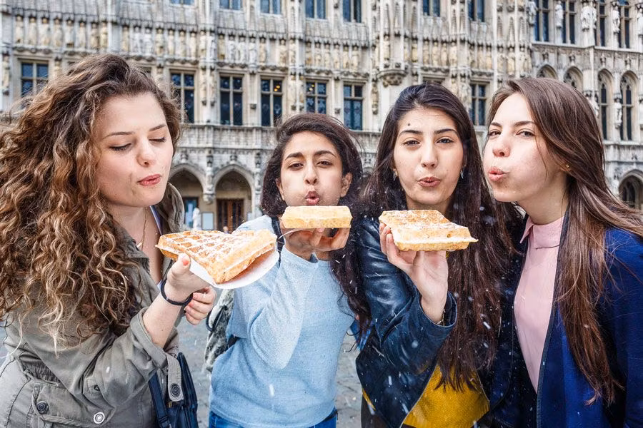 tres jóvenes se toman un gofre en bruselas