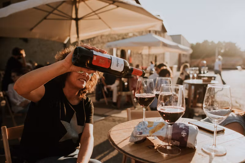 mujer sirviendo una copa de vino