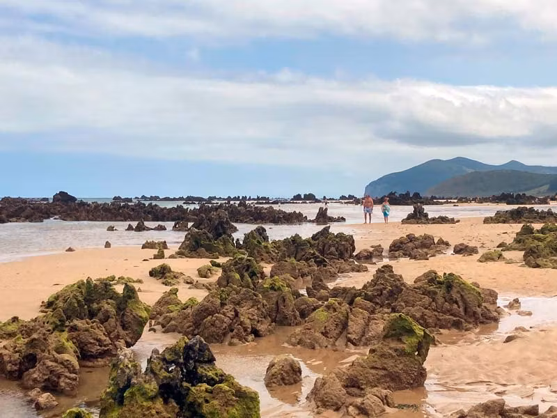 Rocas sobresalen de la arena en Playa de Trengadín, en Cantabria.