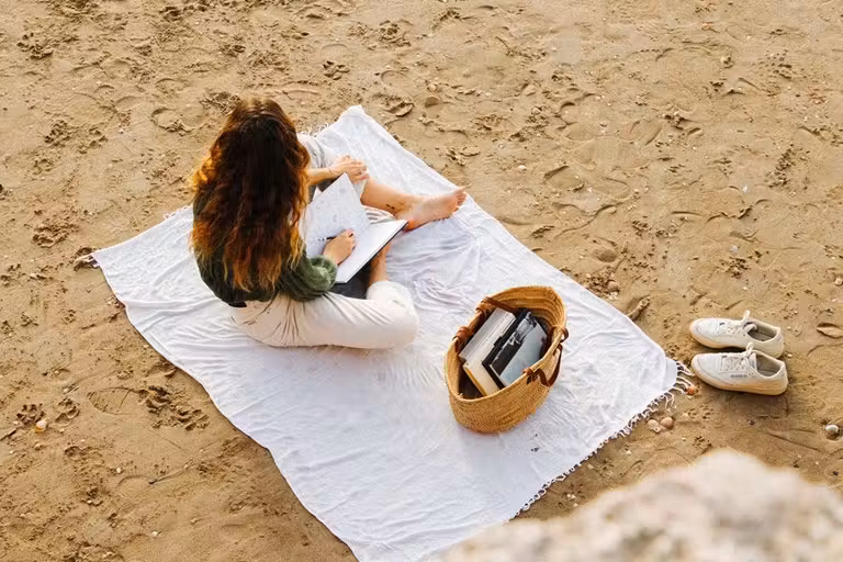 Judit Sánchez sentada en la arena de la playa en Tenerife