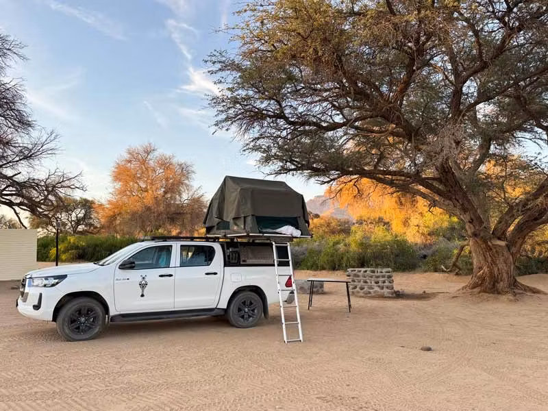Land Rover con tienda de campaña en el techo.