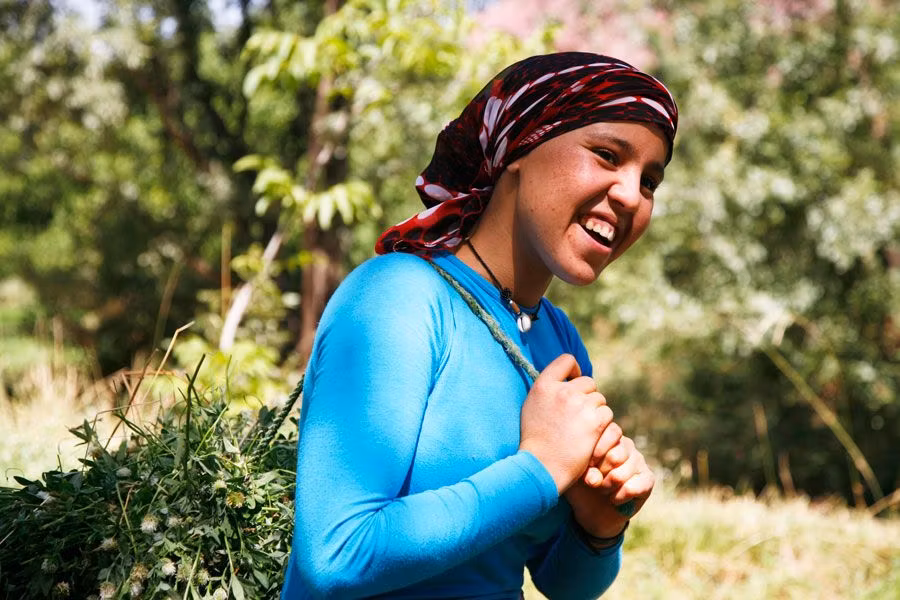 mujer bereber con un fardo de paja