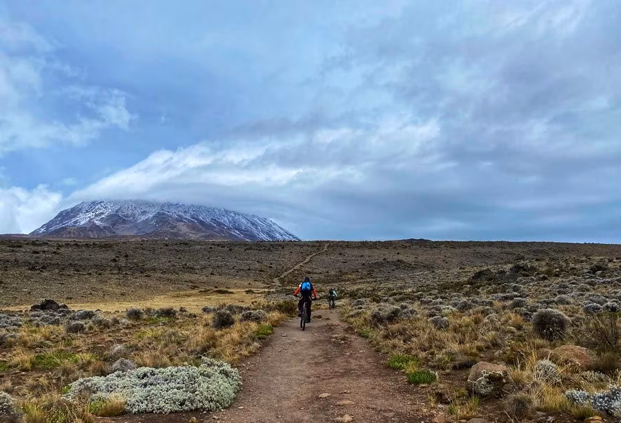 mujeres en bicicleta se dirigen al Kilimanjaro
