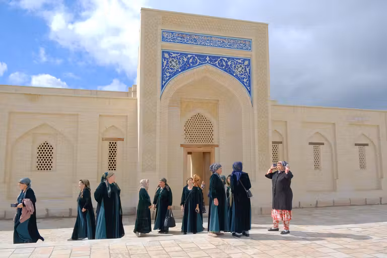 Mujeres uzbekas visitando el Mausoleo Bakhauddin-Nakshbandi, en Bujará. © Susana García