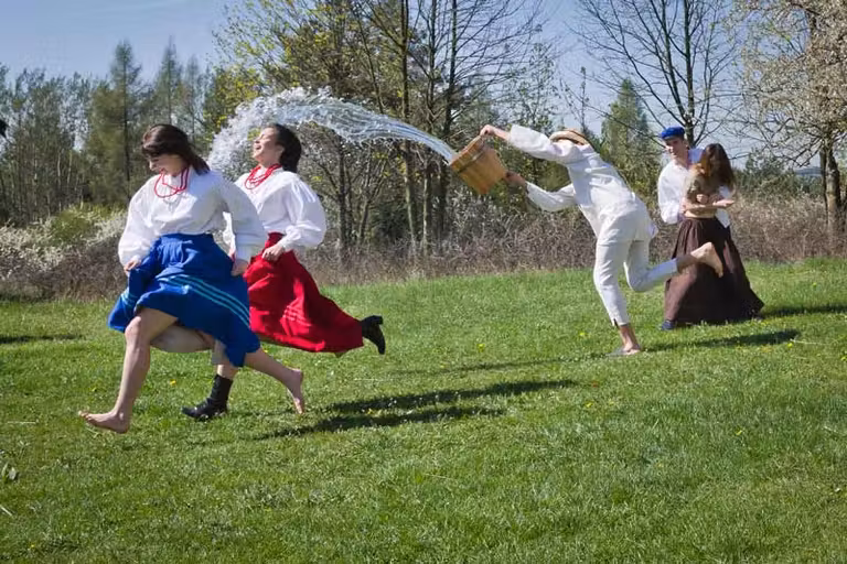 chico echando agua sobre dos chicas en Polonia