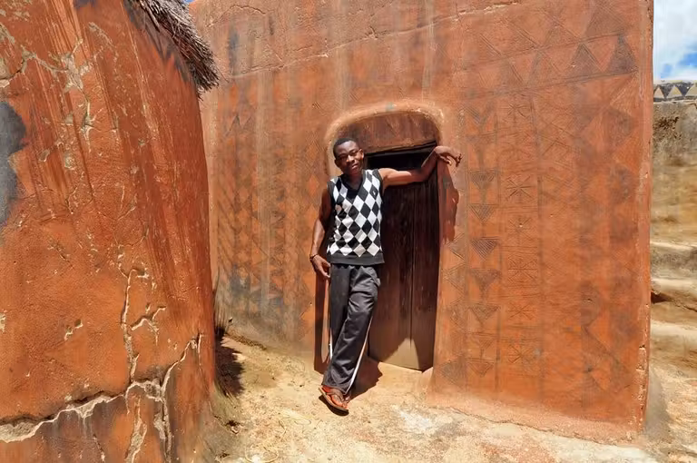 Un joven con jersey de rombos posa frente a una cosa decorada con ese tipo de motivo