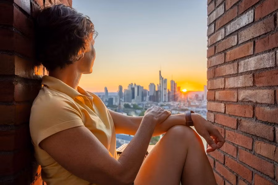 chica mirando Fráncfort en una ventana