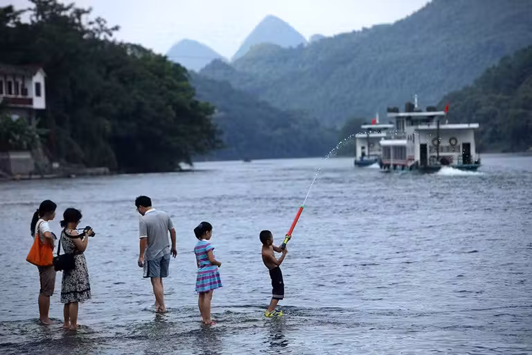 Los niños juegan en la orilla del río Li.