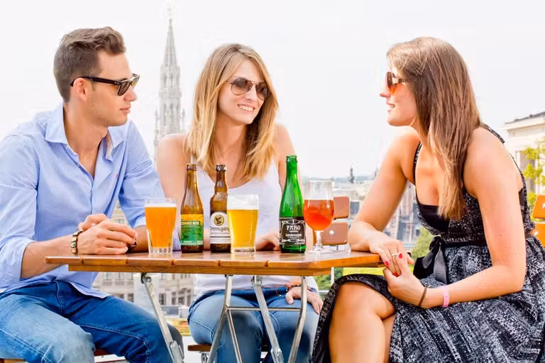 tres jovenes beben cerveza en bruselas
