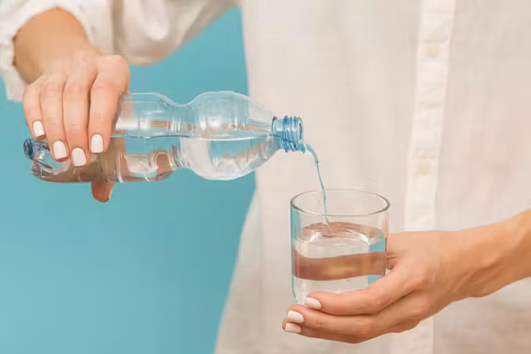 mujer sirviendo un vaso de agua