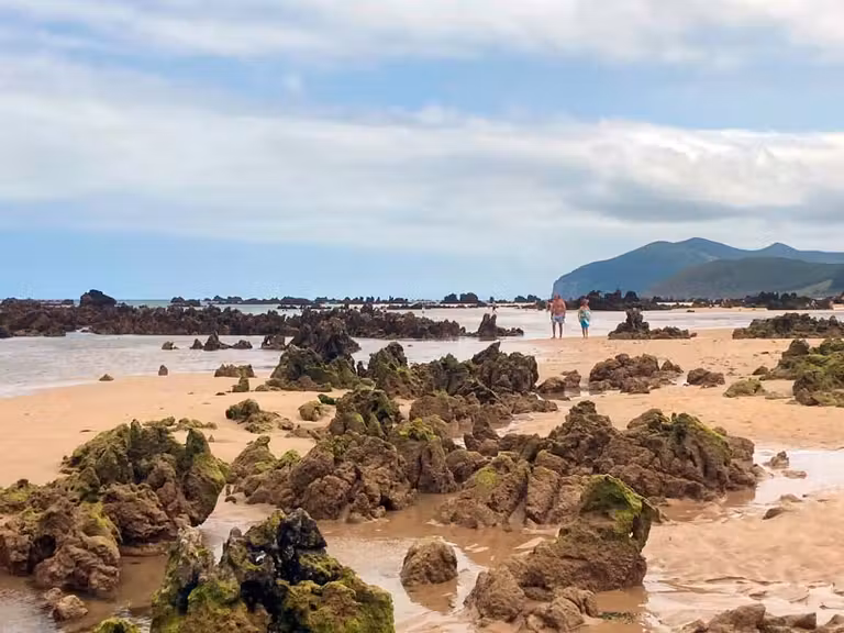 Rocas sobresalen de la arena en Playa de Trengadín, en Cantabria.