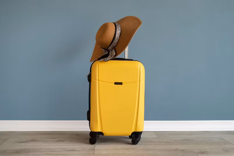 maleta amarilla con sombrero