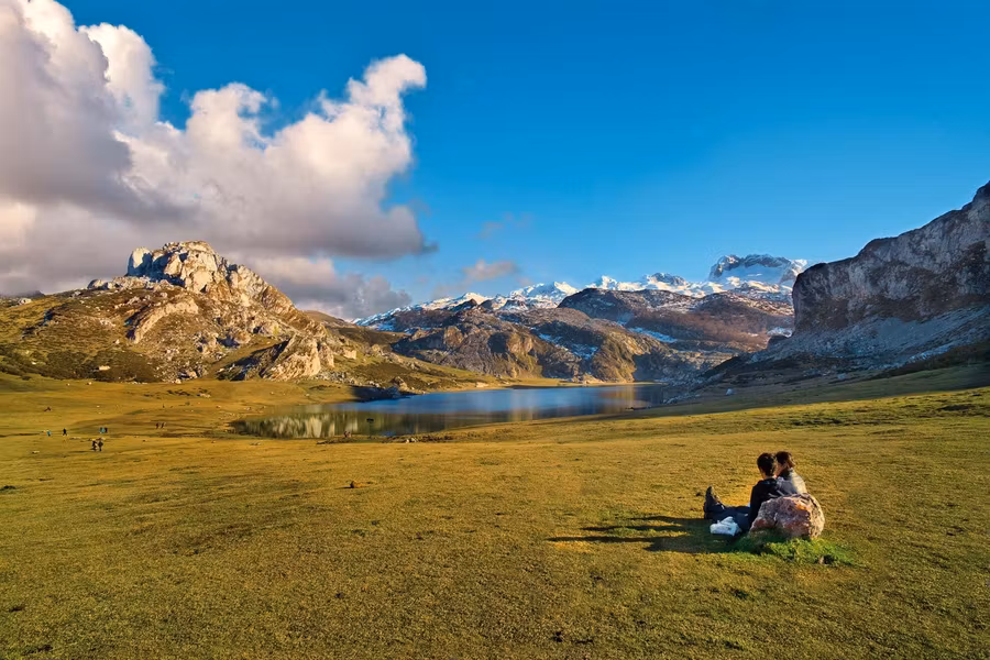 Pareja sentada en lago Covadonga