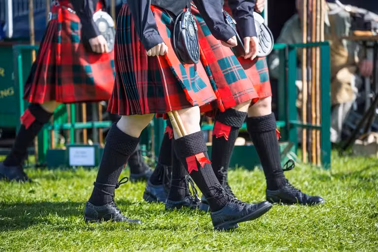 jovenes vestidos con kilt y ropa tradicional escocesa